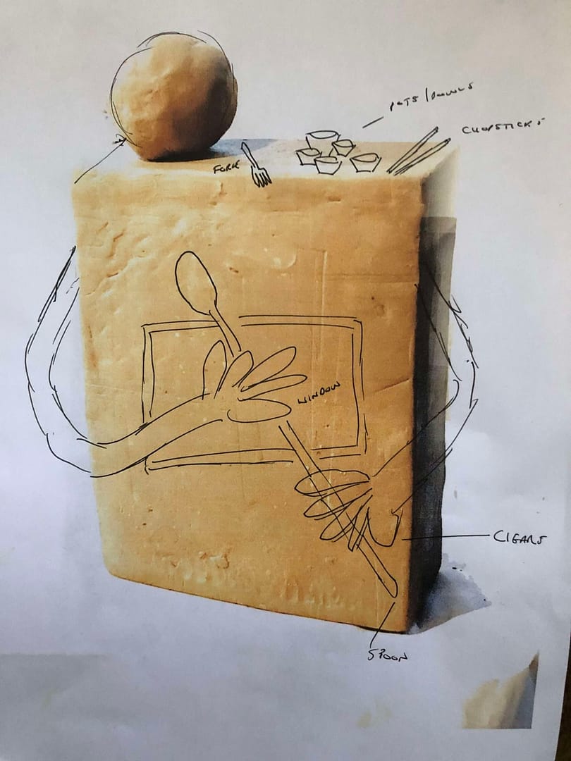 A rectangular in-fired clay model of a kitchen god. The plan shows the design I’m building, including a pair of huge hands, a small, pin-head, a window into the over of its stomach, a spoon to stir things up and various utensils to eat from.
