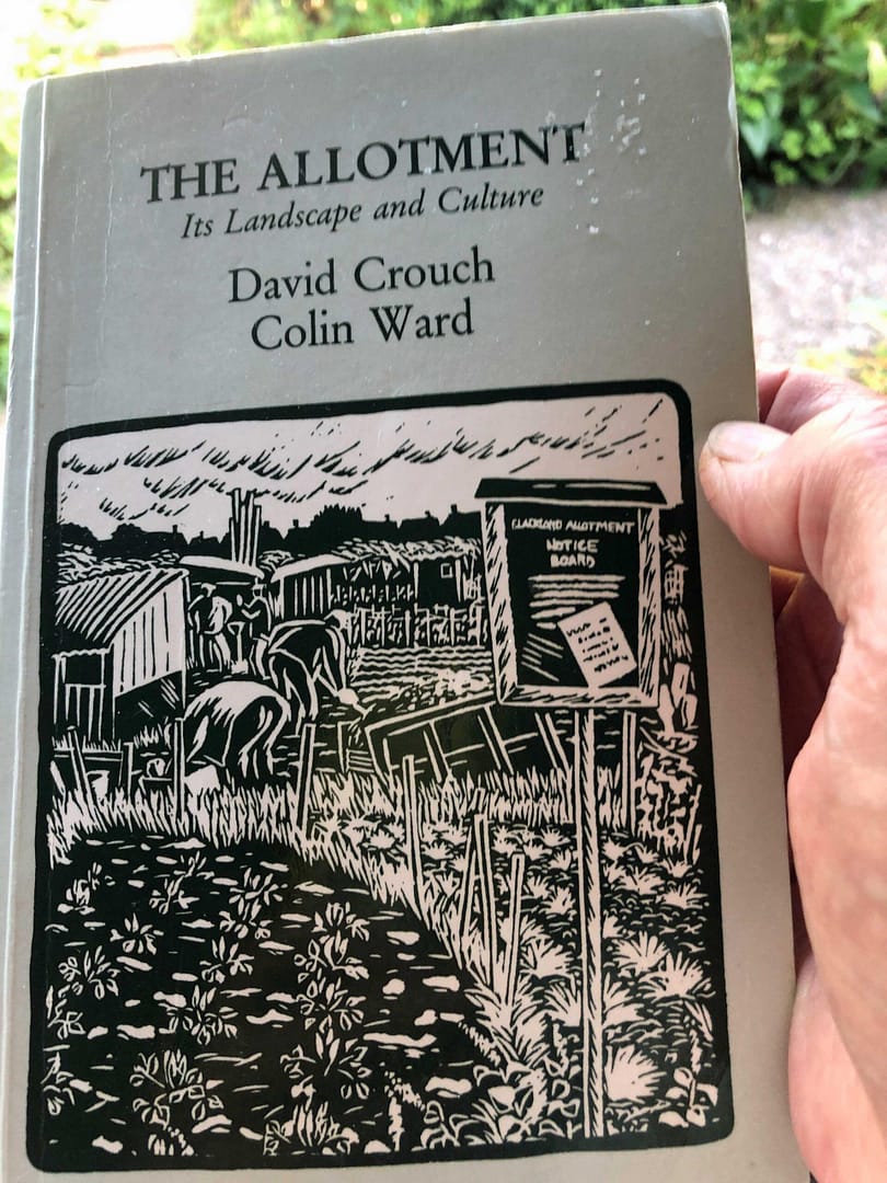 The front cover of the book The Allotment with a delightful B&W lino-cut by artist Kaoru Miyake that is the essence of an allotment. People bent over digging & weeding or leaning on their spade for a break, rows of carefully tended plants & vegetables, stakes to support tomatoes, old poles and wood, littering the area, to be used to build beds or strengthen, little sheds to store & save and shelter. 