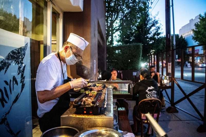 Toshi Sakamaki, chef and owner of Yakitoriya, prepares yakitori outdoors for customers