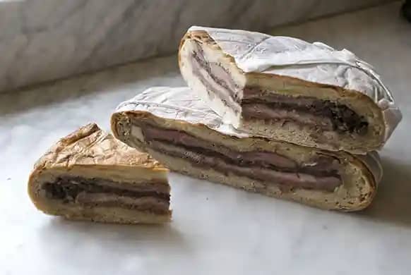 A shooter’s sandwich. Layered slices of steak between a compressed loaf along with various condiments. Sedimentary layers again.
